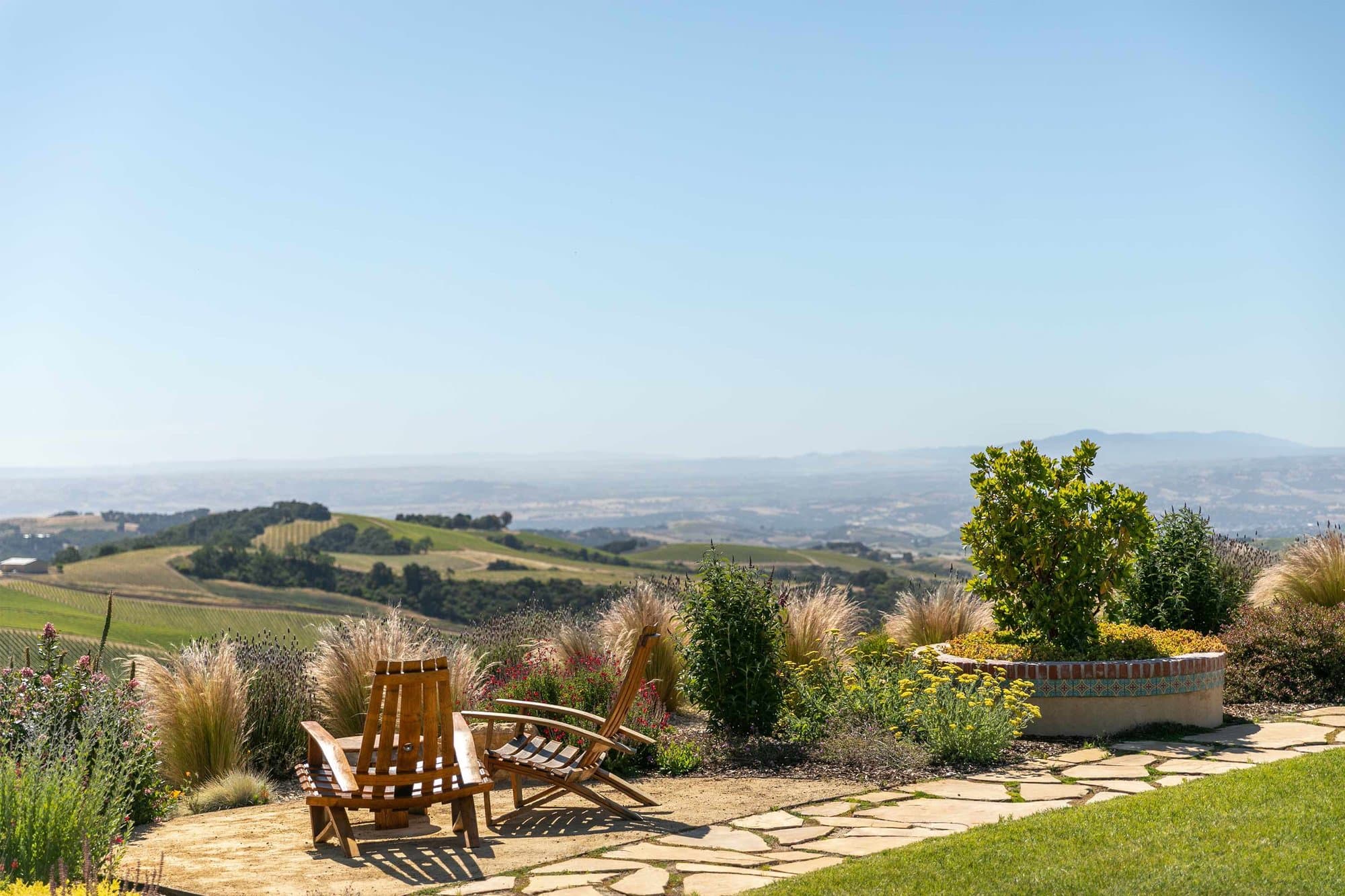Two Adirondack chairs face the vineyards from the DAOU tasting room