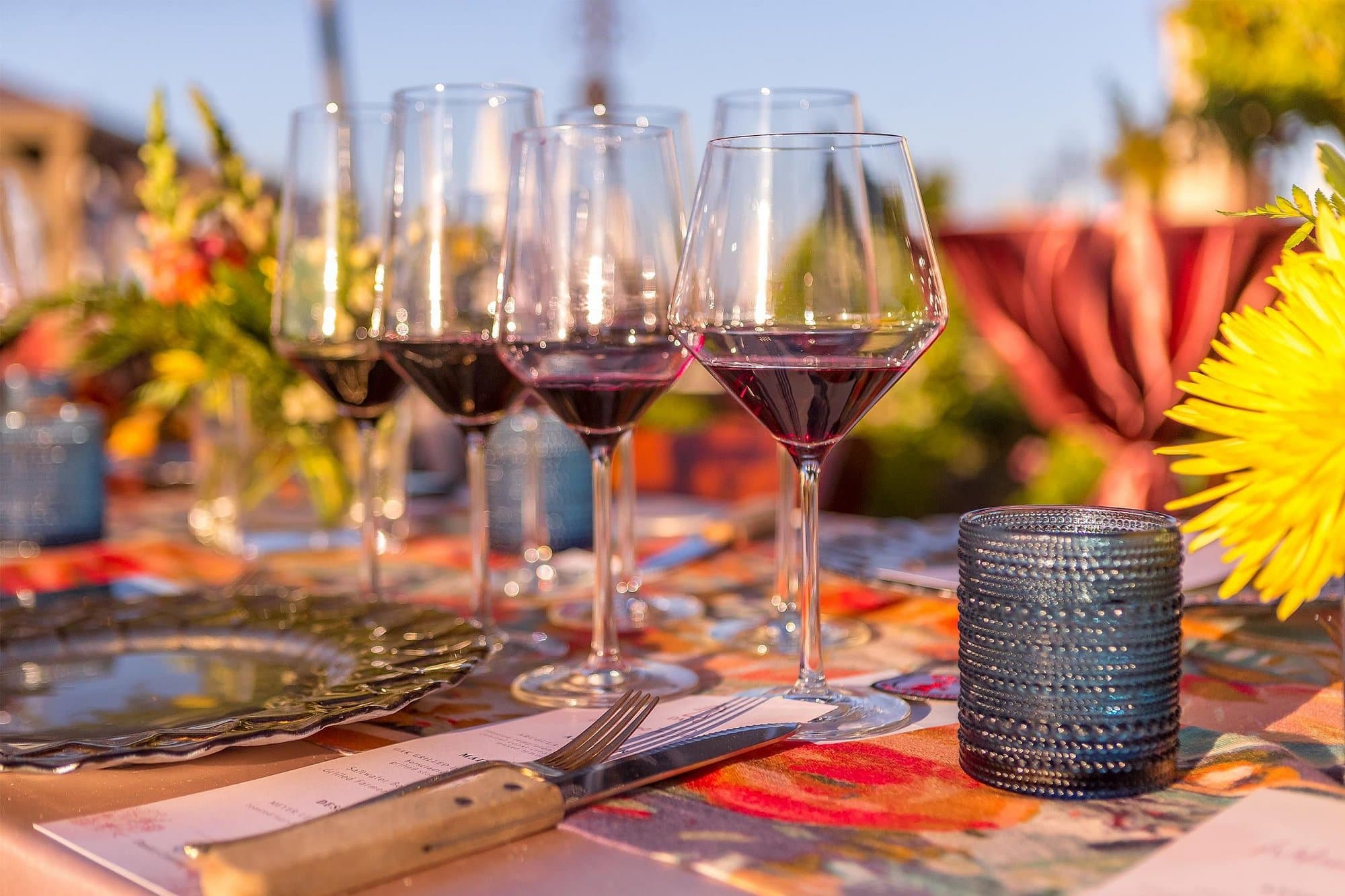 A red wine tasting flight in wine glasses at a set table